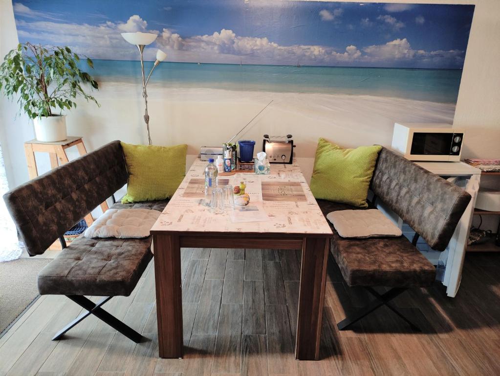 a dining table with two chairs and a painting of the beach at Ferienwohnung Loni In Viereth in Viereth