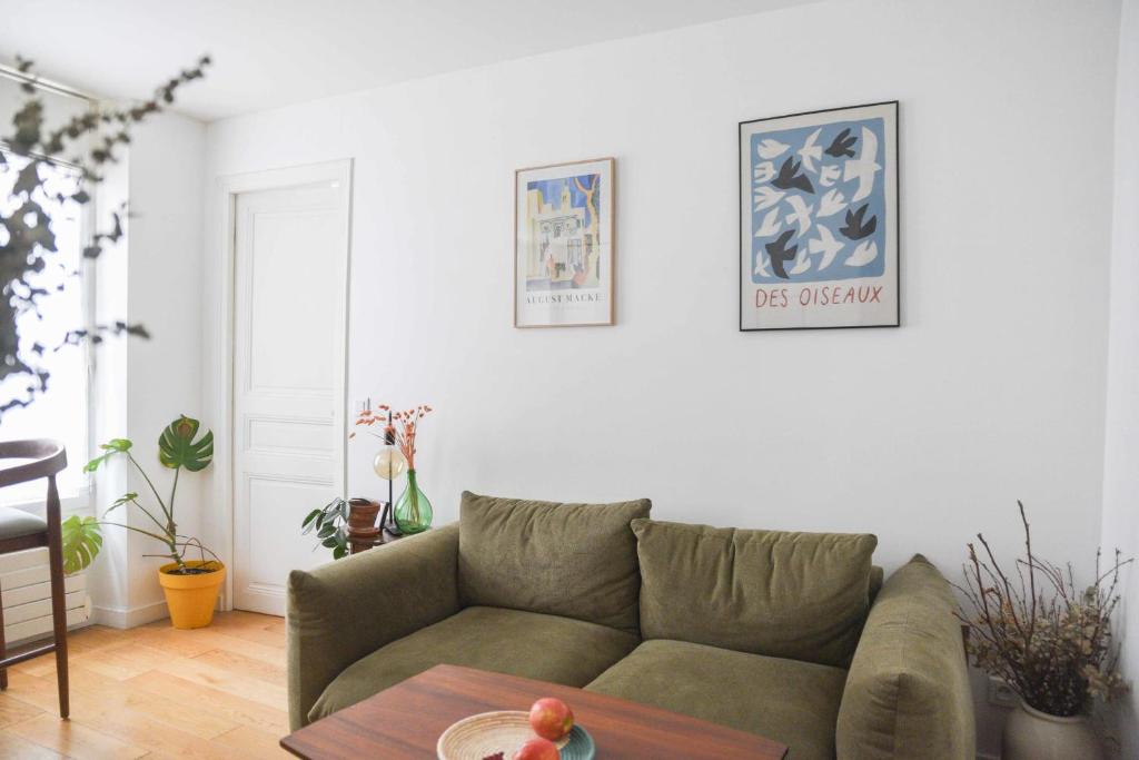 un salon avec un canapé et une table dans l'établissement Bright 1 bedroom apartment - near park, à Paris