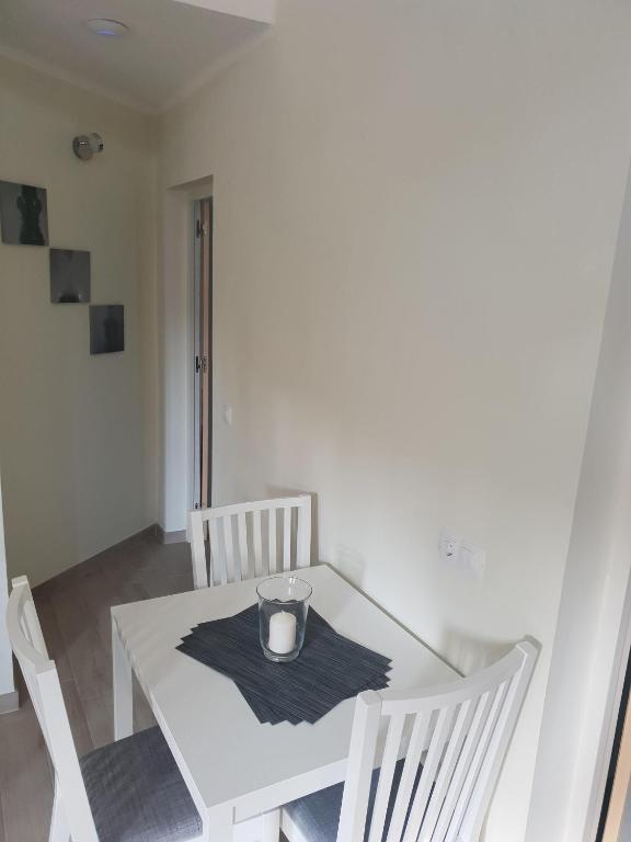 Biały stół z dwoma krzesłami i świecą w obiekcie Ruhige Ferienwohnung Für 4 Personen w Costa Teguise