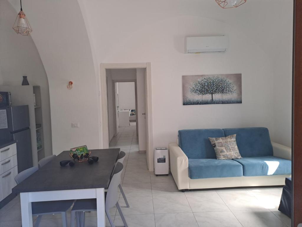 ein Wohnzimmer mit einem blauen Sofa und einem Tisch in der Unterkunft Casa concy in Sant'Agnello