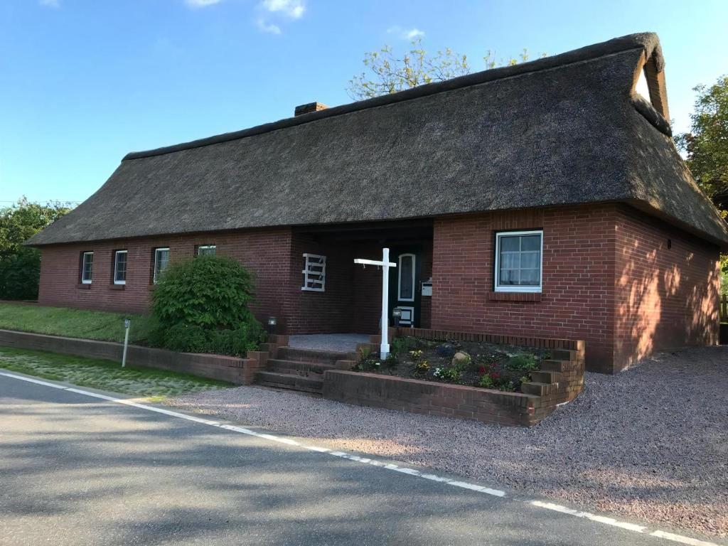 une église avec une croix devant elle dans l'établissement Gemütliches Reetdachhaus In Schleswig Holstein, à Neuendorf-Sachsenbande