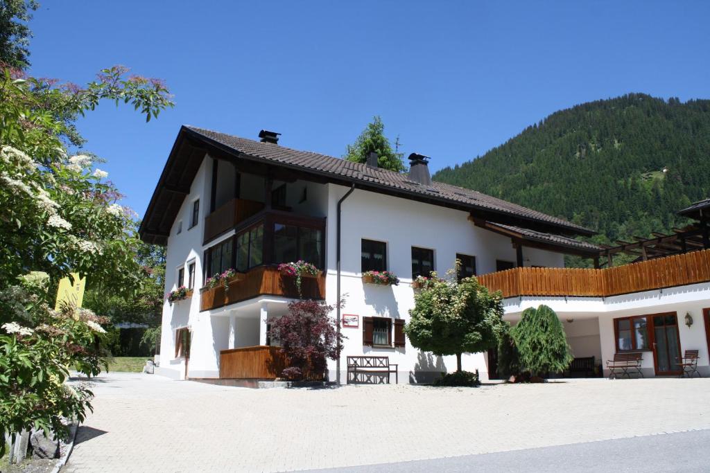 a white building with a mountain in the background at Ruhiges Appartement In St Gallenkirch in Sankt Gallenkirch
