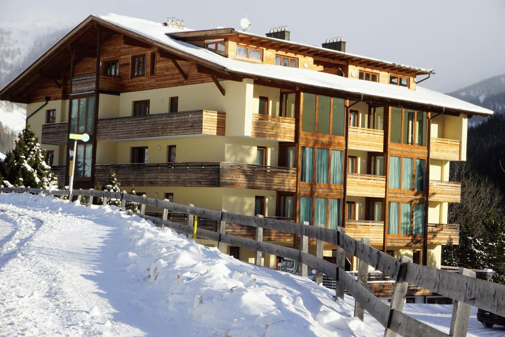 a building in the snow with a fence at Ferienwohnung Design Chalet In Bad Kleinkirchheim in Bad Kleinkirchheim