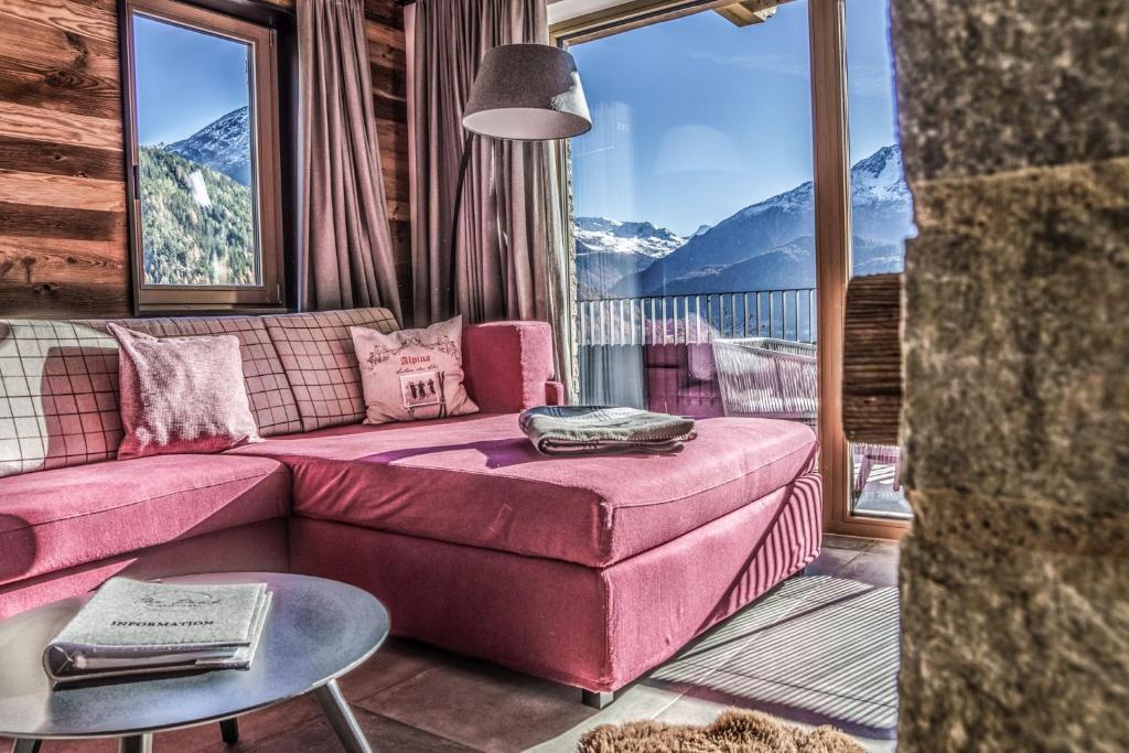 sala de estar con sofá rosa y ventana grande en Jagd Chalet Sölden, en Sölden
