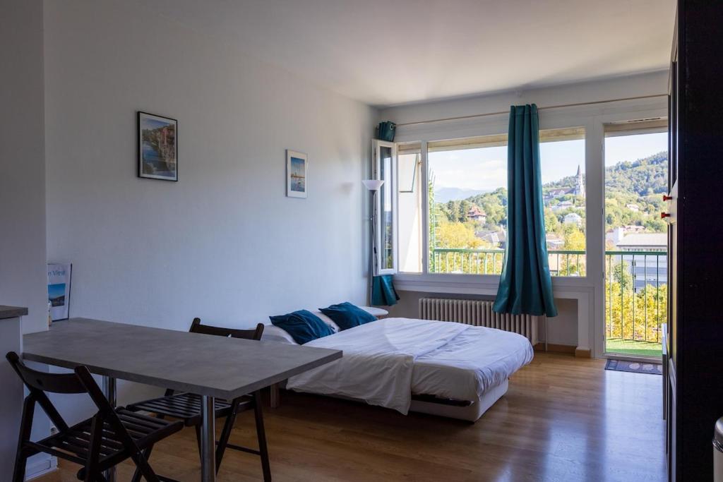 une chambre avec un lit, une table et une fenêtre dans l'établissement Panoramic Seven View, à Annecy