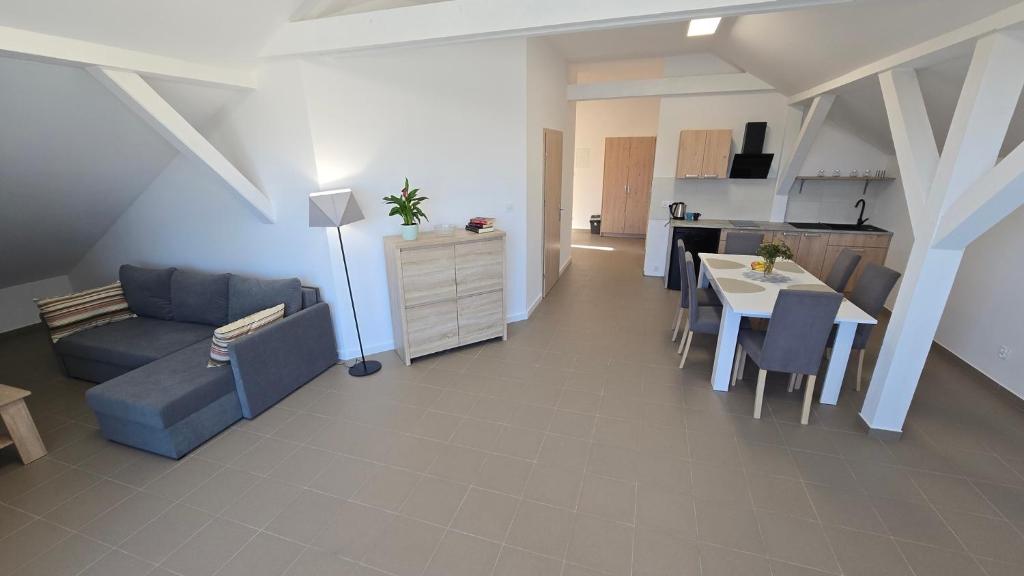 Una sala de estar con un sofá y una mesa y una cocina. en Apartament Camping Portowy, en Mrzeżyno