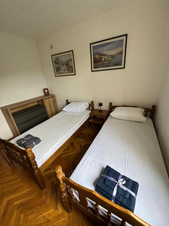 two twin beds in a room with a cross on them at Adriatic Escape Apartment in Herceg-Novi