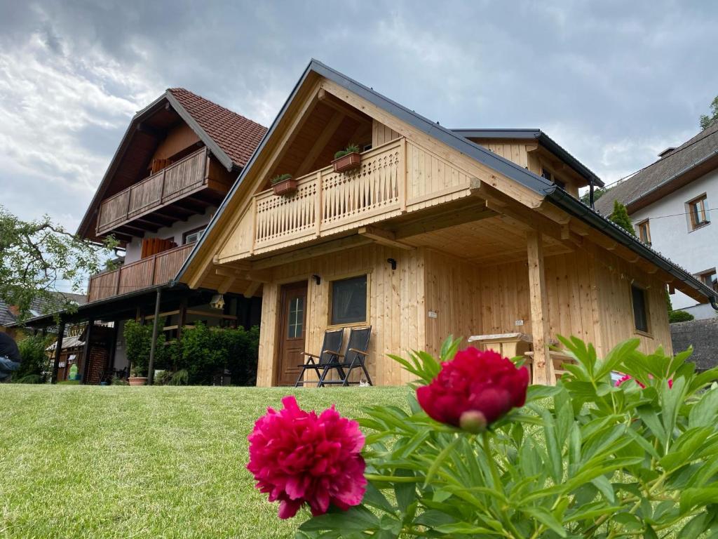 a house with a balcony and two pink flowers at Princess Mojca Holiday House in Bled