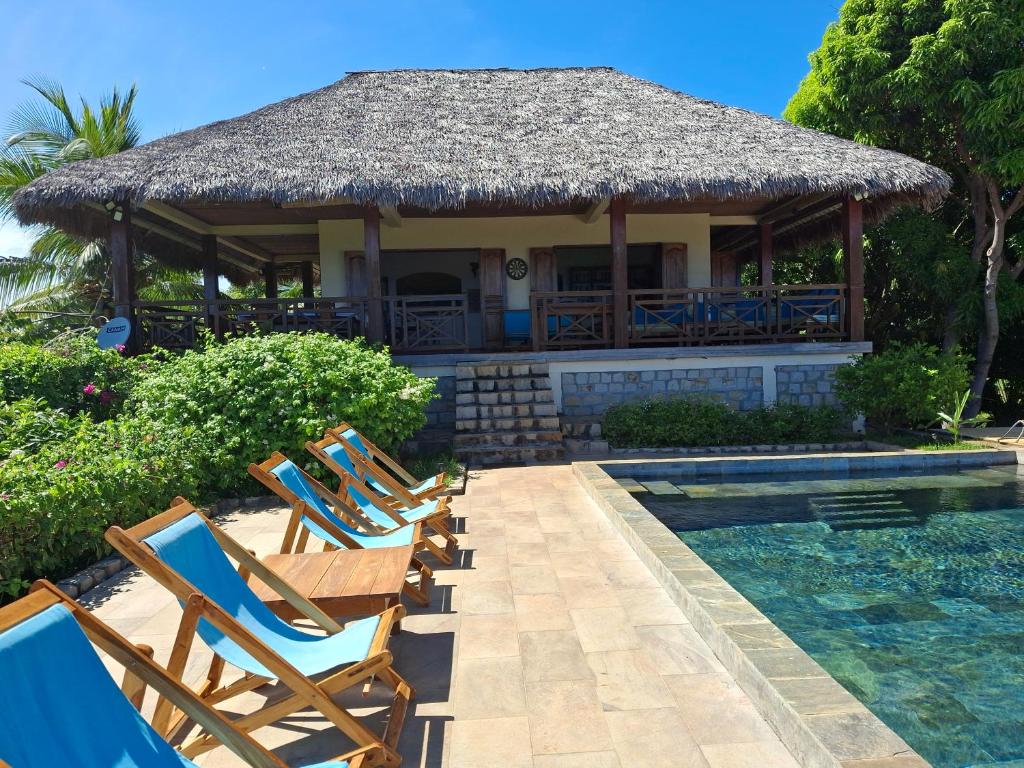 a group of chairs sitting next to a swimming pool at Résidences-Bel-R in Nosy Be