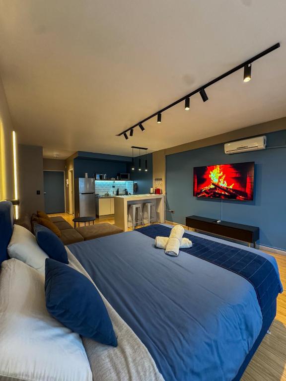 a bedroom with a large blue bed and a kitchen at Foster Studio - Nicaragua in Buenos Aires