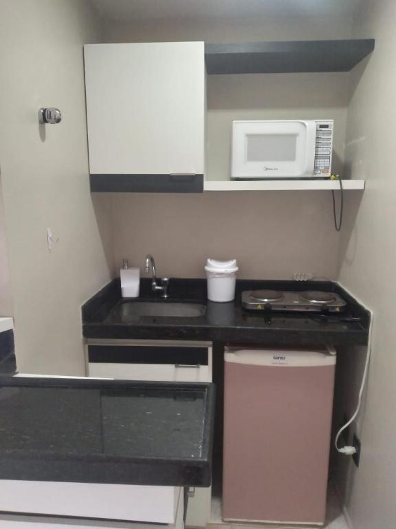 a small kitchen with a sink and a microwave at Victory Flat Intermares in Cabedelo
