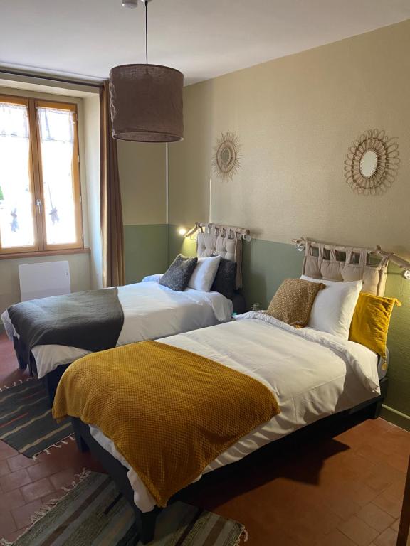 a bedroom with two beds with yellow and white sheets at les petits sportifs in Léré