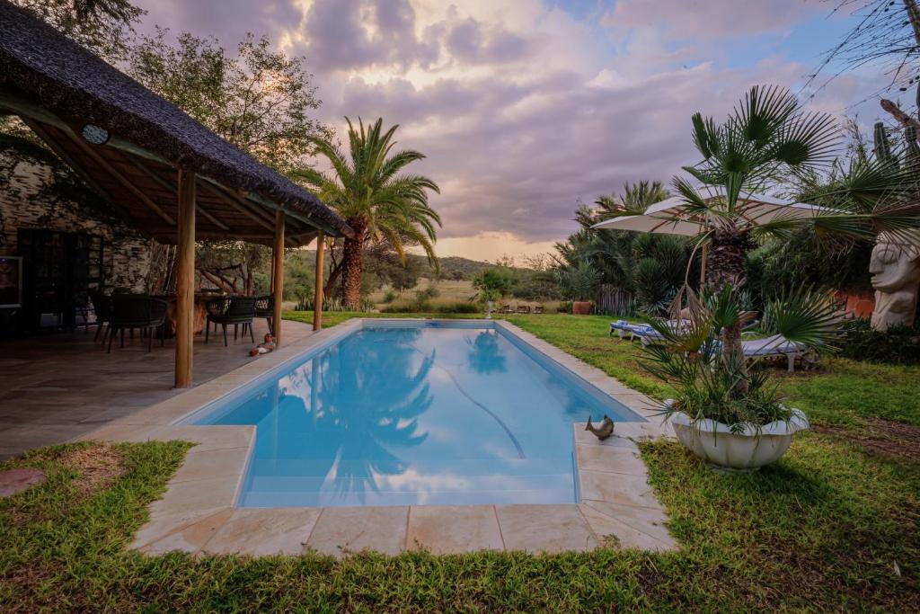 a swimming pool in the yard of a house at Ohorongo Safari Lodge in Kamanjab