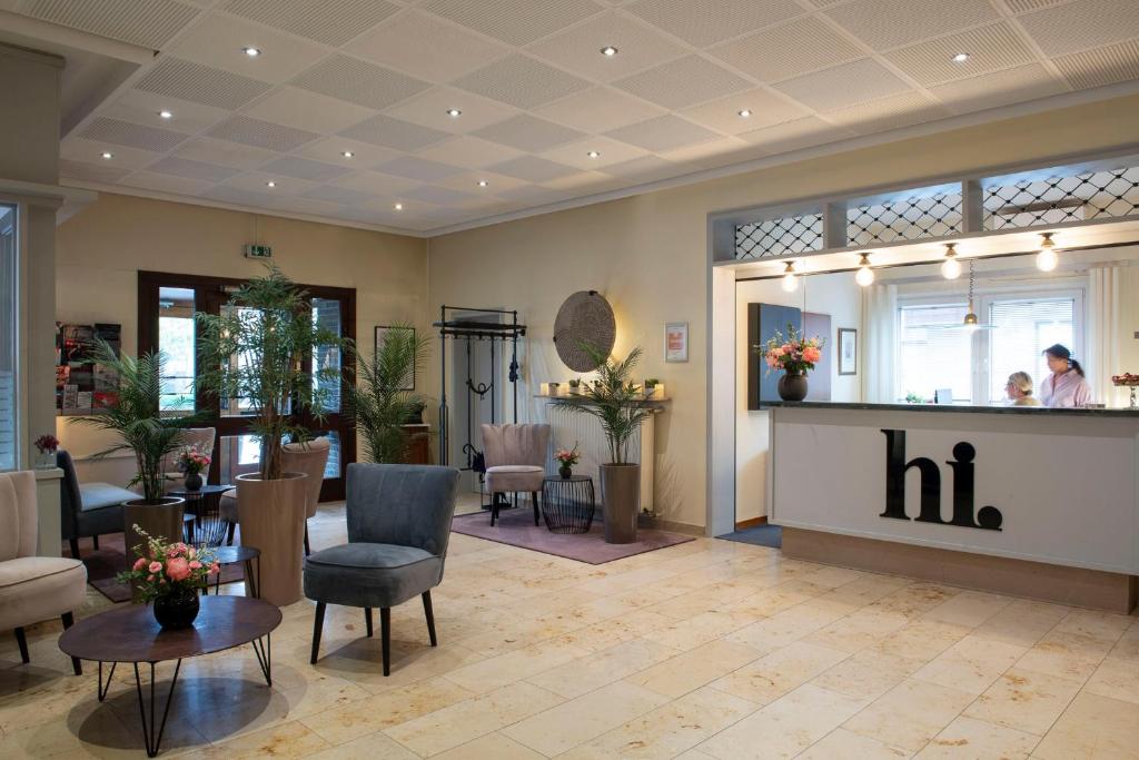 a salon with a waiting room with a mirror at Hotel Alte Post in Krefeld