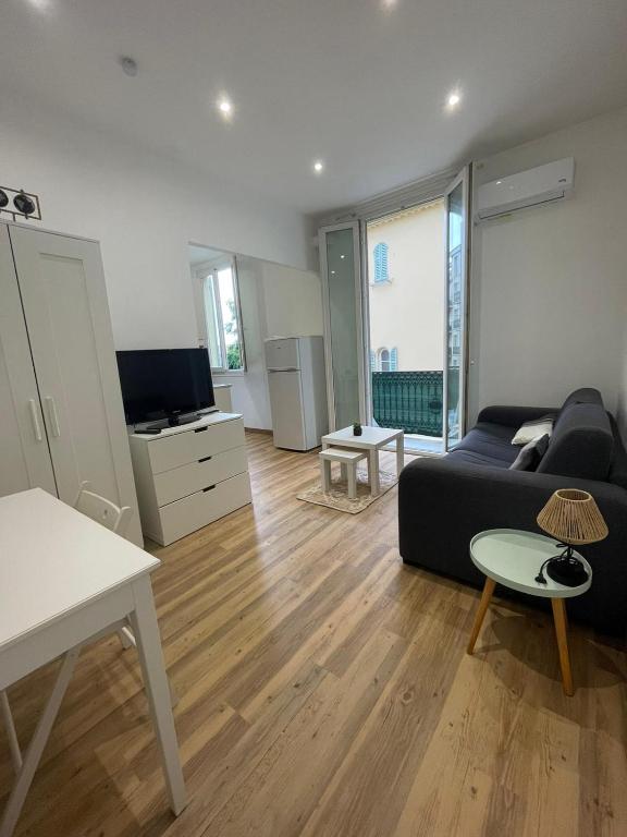 un salon avec un canapé et une télévision dans l'établissement Studio Climatisé Coeur Nice, à Nice
