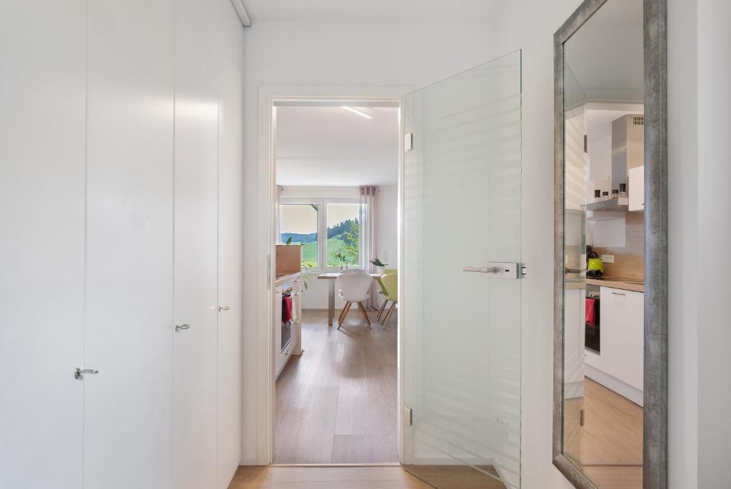 a white hallway with a mirror and a kitchen at Fewo Furtwangen in Furtwangen