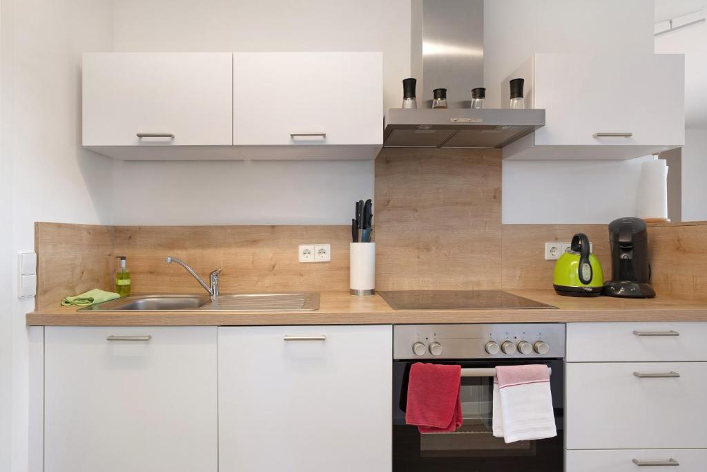 a kitchen with white cabinets and a sink at Fewo Furtwangen in Furtwangen