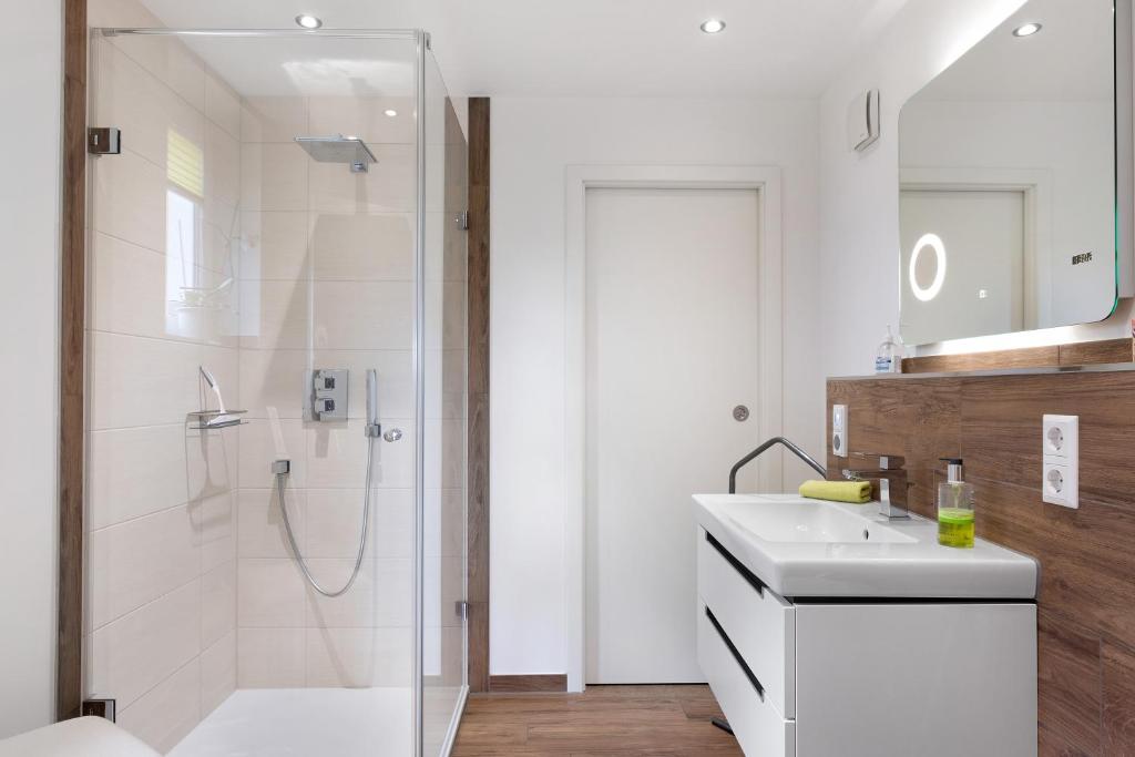 a white bathroom with a shower and a sink at Fewo Furtwangen in Furtwangen