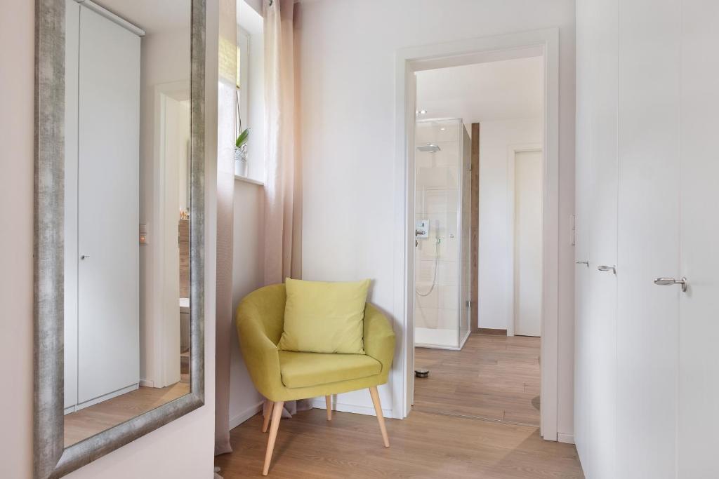 a yellow chair in a hallway with a mirror at Fewo Furtwangen in Furtwangen
