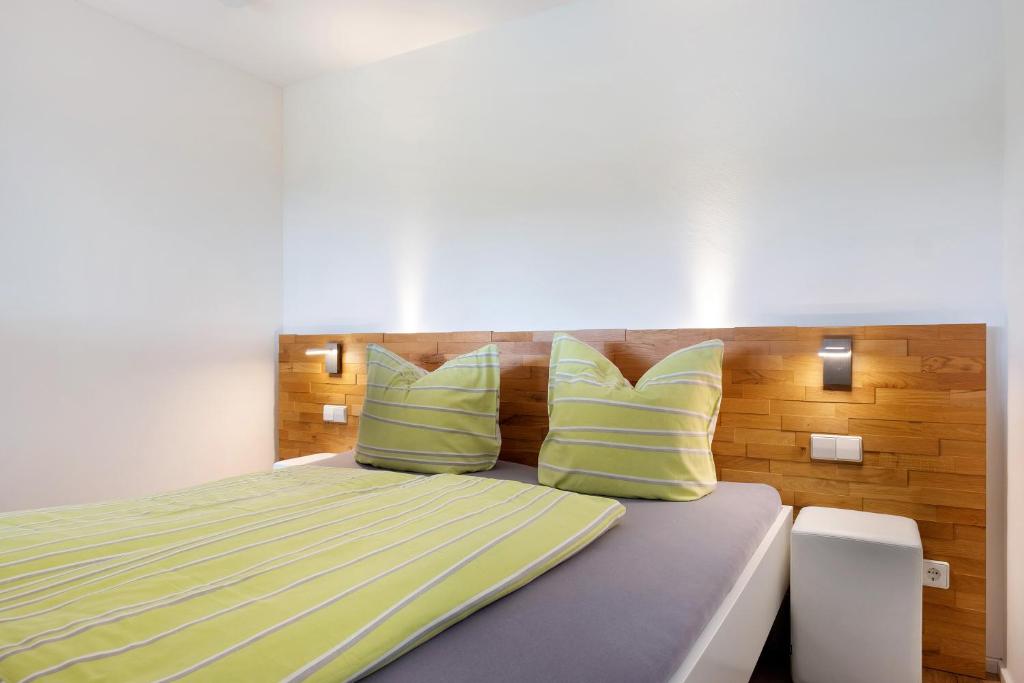 a bedroom with a bed with green and yellow pillows at Fewo Furtwangen in Furtwangen