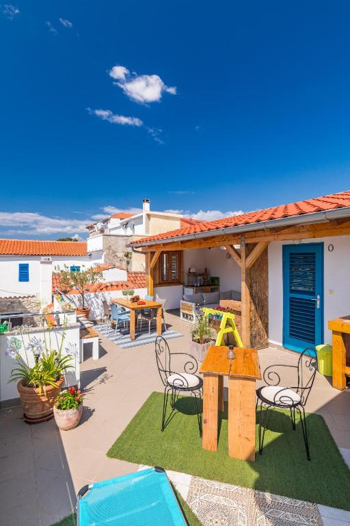a patio with a table and chairs and a house at Yvonne in Krk