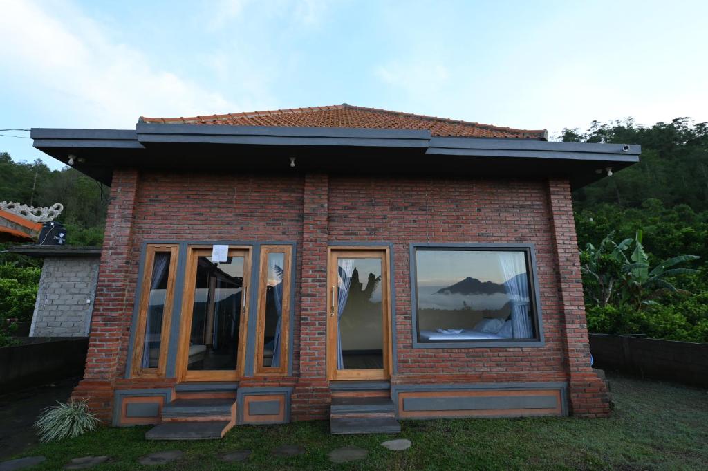 a small red brick house with two windows at Pondok Alas Guests House in Gretek