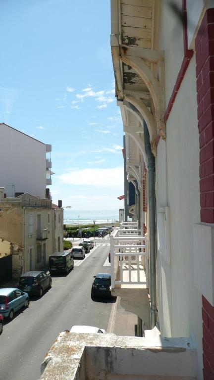 un balcon d'un immeuble avec des voitures garées dans une rue dans l'établissement Maison familiale de vacances, à La Rudelière