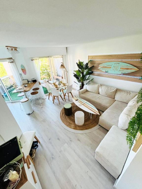 un salon avec un canapé et une table dans l'établissement Appartement 211 - LES SUITES DE ROBINSON - Résidence avec piscine en bord de Siagne, à Mandelieu-La-Napoule, à Mandelieu-la-Napoule