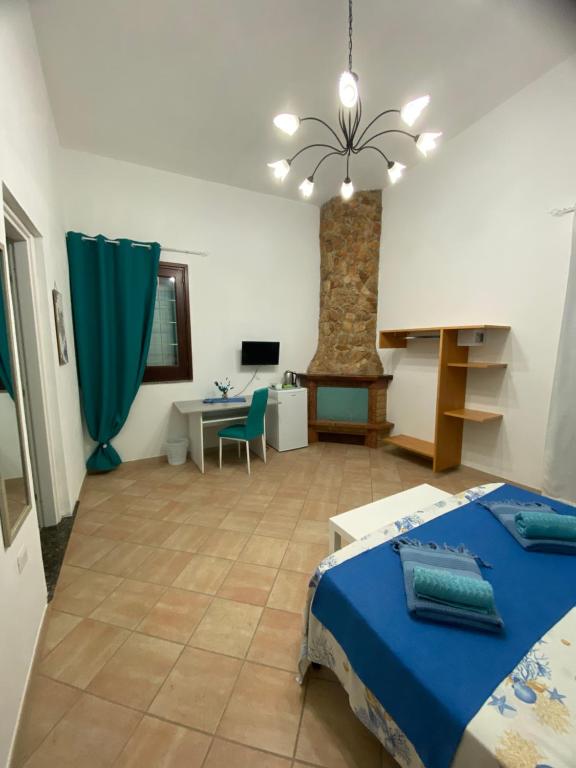a bedroom with a bed and a desk and a table at L’Olimpo sul mare in Lampedusa