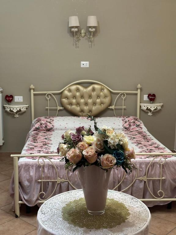 sypialnia z łóżkiem z wazą kwiatów na stole w obiekcie B&B la reggia w mieście Caserta
