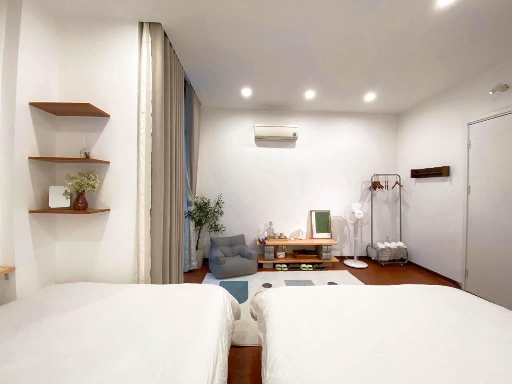 two beds in a room with white walls at Chiri Homestay in Thôn Trường Giang