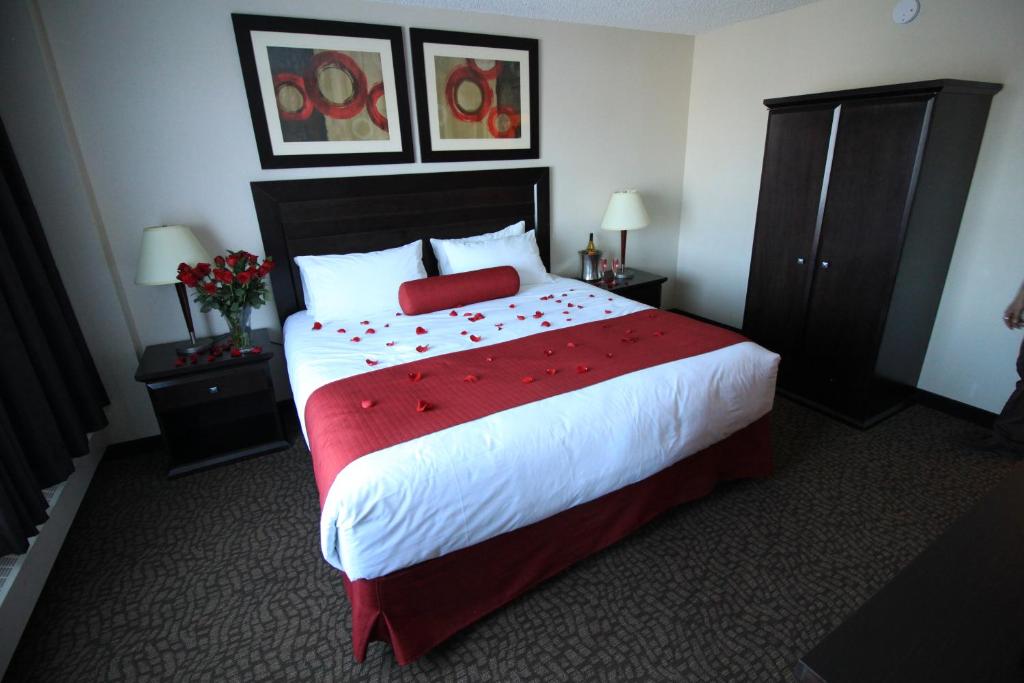 a bedroom with a large bed with a red blanket at Century Casino & Hotel Edmonton in Edmonton