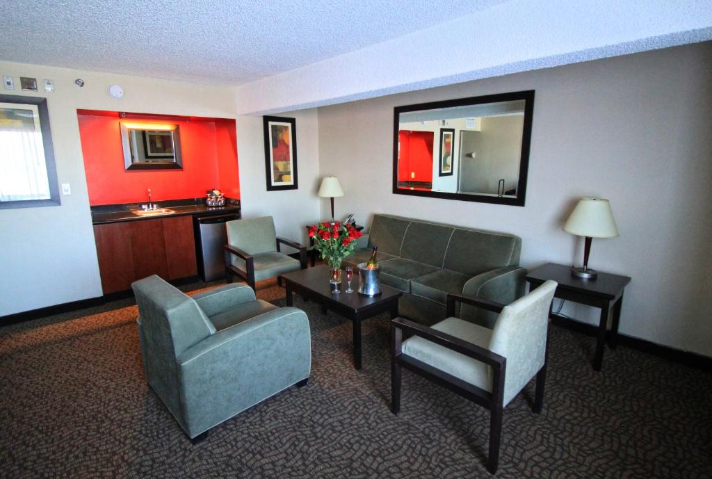 a living room with a couch and chairs and a mirror at Century Casino & Hotel Edmonton in Edmonton