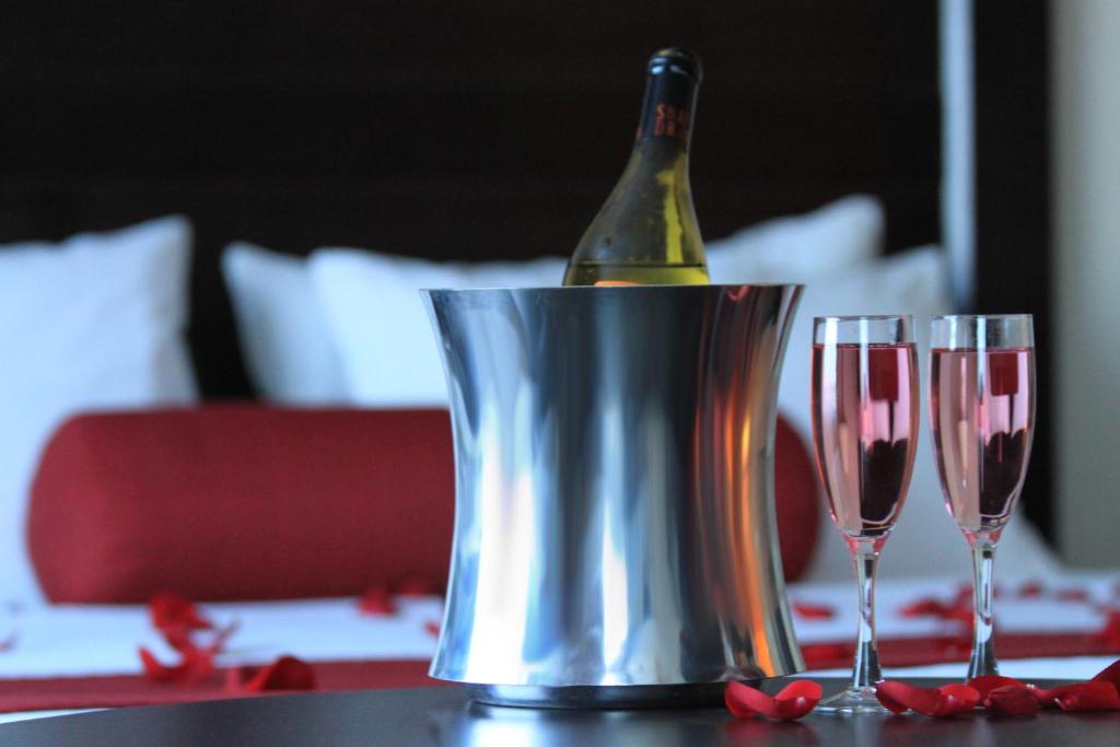 a bottle of wine in a bucket on a table with two glasses at Century Casino & Hotel Edmonton in Edmonton