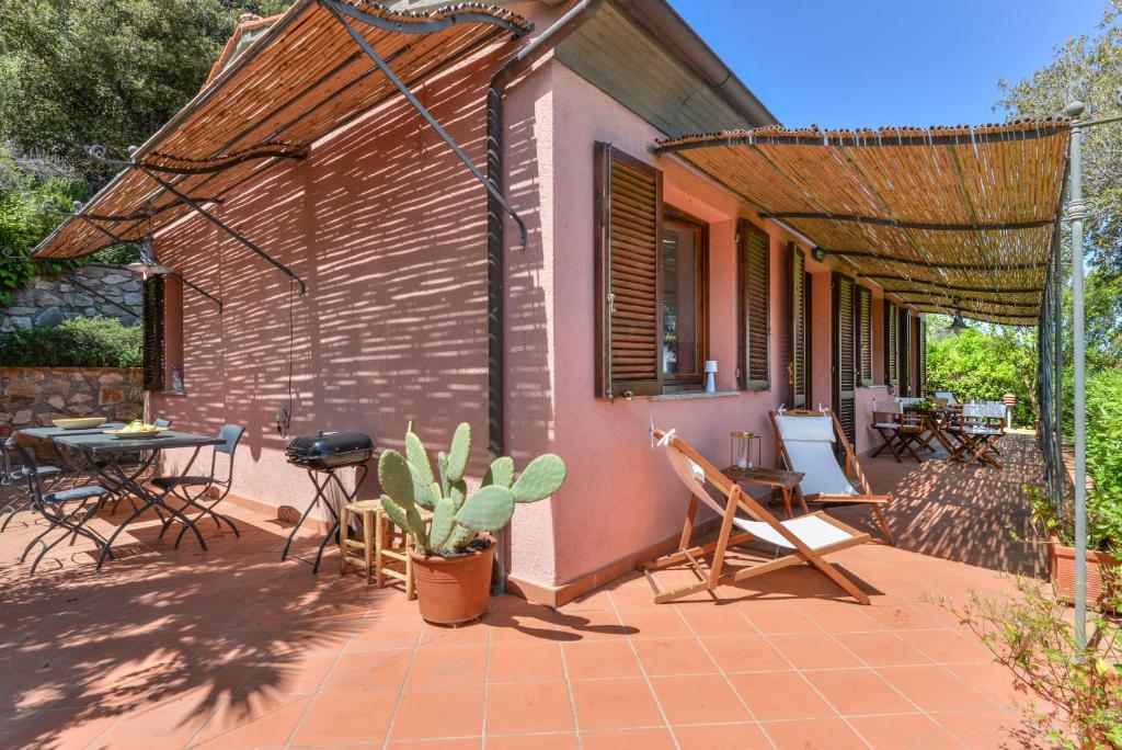 a patio of a house with a table and chairs at Villino Martini in Marciana