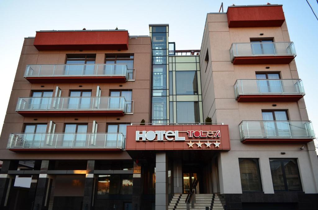 un hôtel avec un panneau sur le côté d'un bâtiment dans l'établissement Hotel Tolea, à Târgovişte