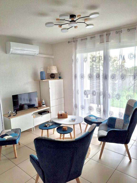 un salon avec une table et des chaises dans l'établissement Ô Soleil - Spacieux studio entre mer & montagne parking wifi clim, à Saleilles