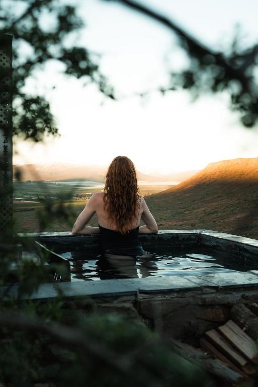 a woman is sitting in a bath tub at Khanyisa Mountain Lodge in Robertson