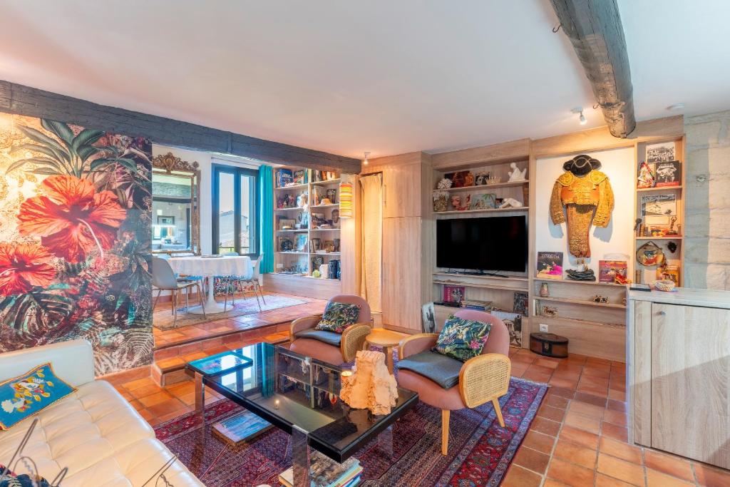 un salon rempli de meubles et d'une télévision à écran plat dans l'établissement En plein centre d'Avignon, à Avignon