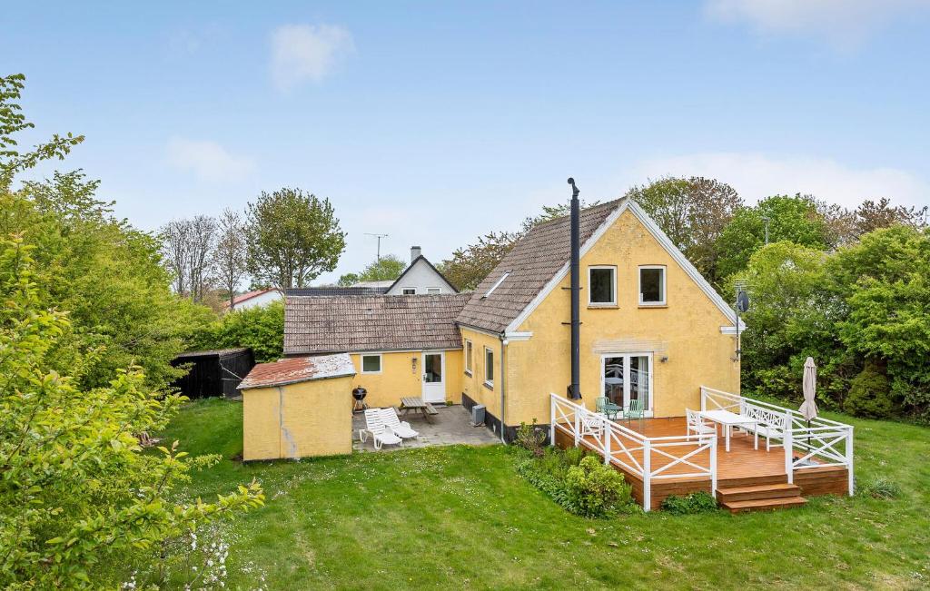 a yellow house with a porch and a yard at 4 Bedroom Amazing Home In Østermarie in Østermarie