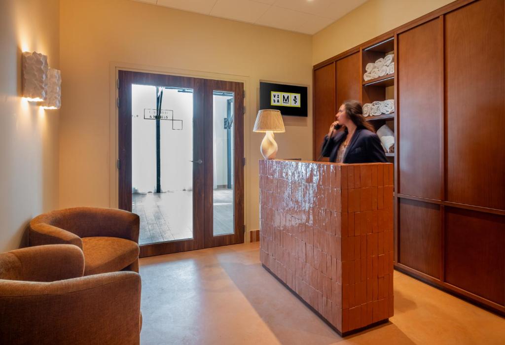 a woman talking on a cell phone in a room at Hôtel Villa M Marseille in Marseille