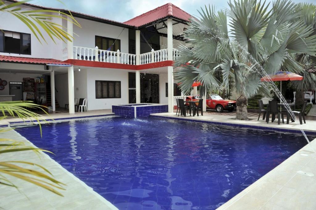uma villa com piscina em frente a uma casa em Casa de Huespedes Villa Hermosa em La Vega