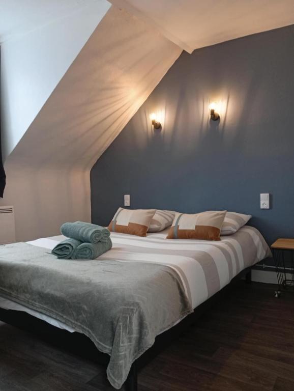 - une chambre avec un grand lit et un plafond pointu dans l'établissement La Cabane du Pêcheur, à Dieppe