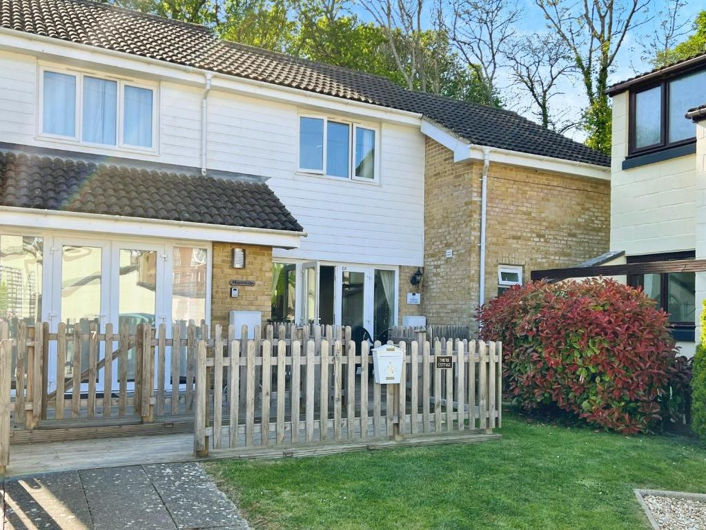 Thistle Cottage في Wootton Bridge: حاجز خشبي أمام المنزل