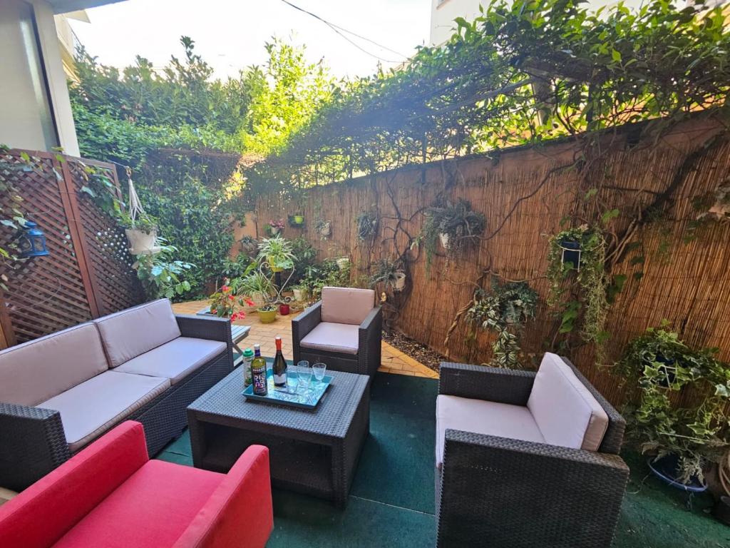 d'une terrasse avec des canapés, des chaises et une table. dans l'établissement A 1 min de la plage! Bel appartement T4 avec petit jardin, à Fréjus