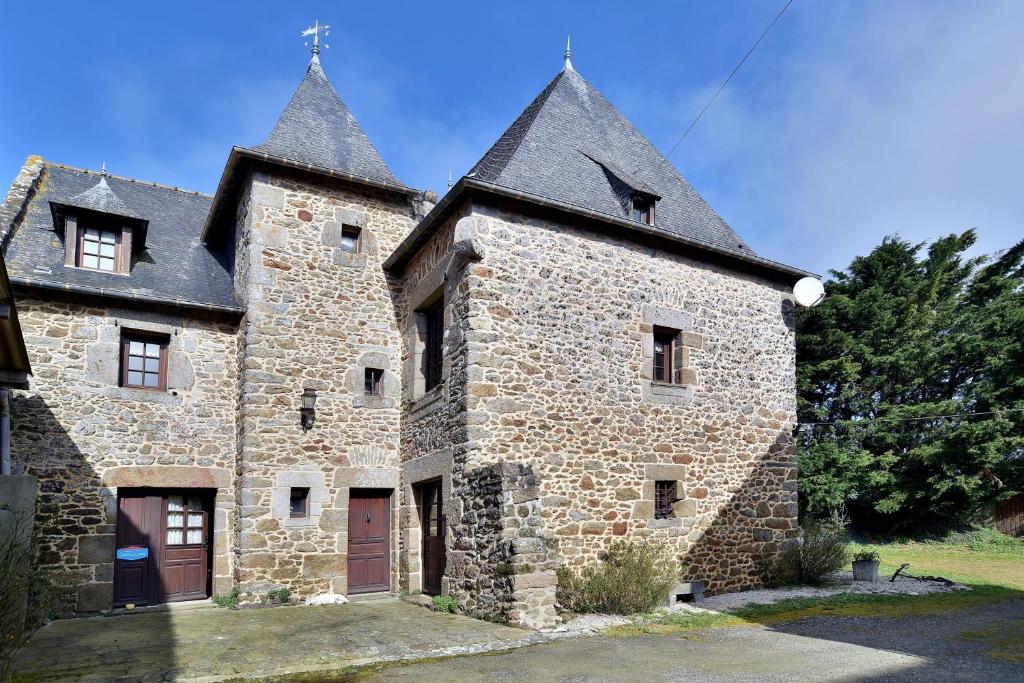 un ancien bâtiment en pierre avec un toit noir dans l'établissement Gîte Les Croix Gibouins, à Saint-Méloir-des-Ondes