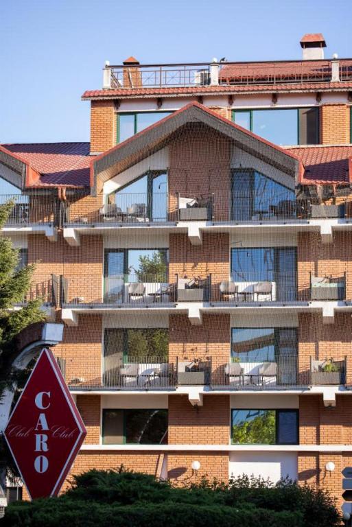 a tall brick building with chairs on a balcony at Caro Hotel in Bucharest