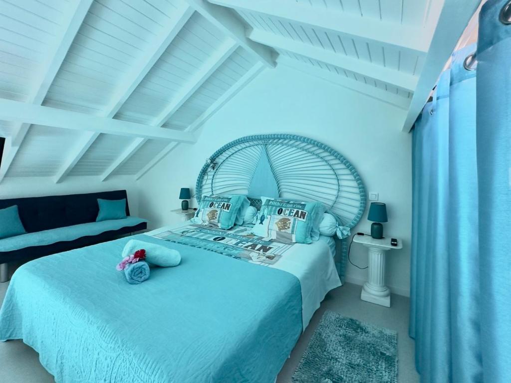 a bedroom with a white bed with a white ceiling at Sun Caraibes in Orient Bay