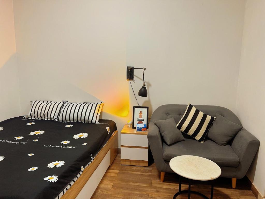 a bedroom with a bed and a couch and a chair at FlexiHome in Ho Chi Minh City