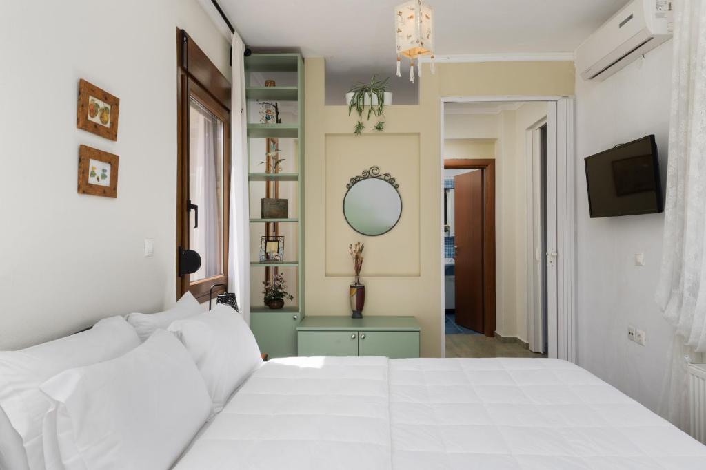 a bedroom with a white bed and a mirror at Frida & Rosa by halu! - Villas in Kriopigi in Kriopigi